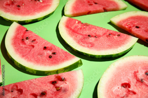Slices of ripe watermelon on green background, closeup