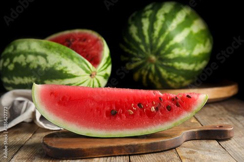 Board with yummy watermelon slice on wooden table