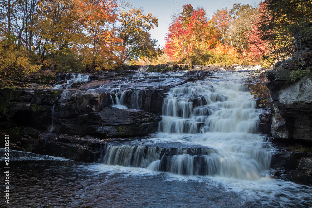 Peak fall foliage surrounds beautiful cascading lower Shohola Falls on an Autumn morning in the Pennsylvania Poconos Peak fall foliage surrounds beautiful cascading lower Shohola Falls on an Autumn morning in the Pennsylvania Poconos