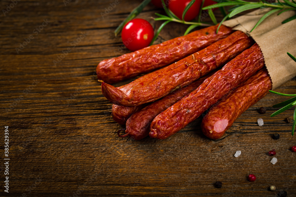 Kabanos or Cabanossi Thin Dry Smoked Polish Sausage on Wooden Background. Selective focus.