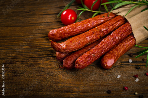 Kabanos or Cabanossi Thin Dry Smoked Polish Sausage on Wooden Background. Selective focus.