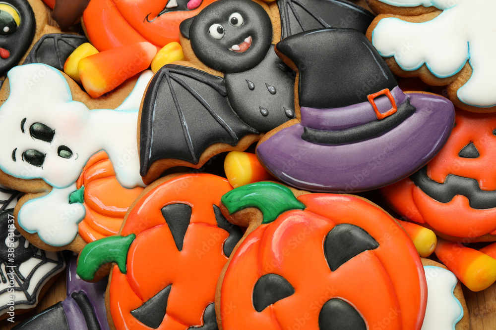 Top view of tasty cookies and sweets for Halloween party as background, closeup