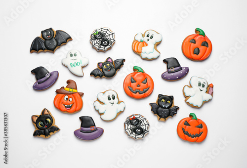 Tasty Halloween cookies on white table, flat lay