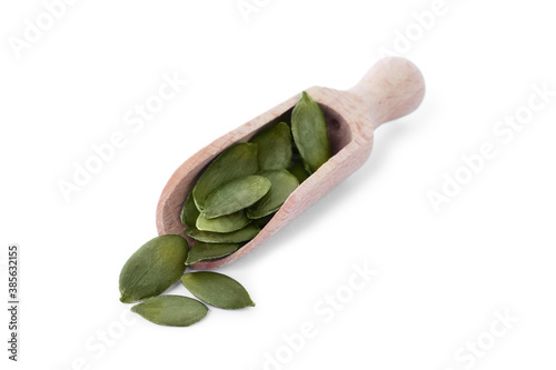 Peeled pumpkin seeds in wooden scoop isolated on white