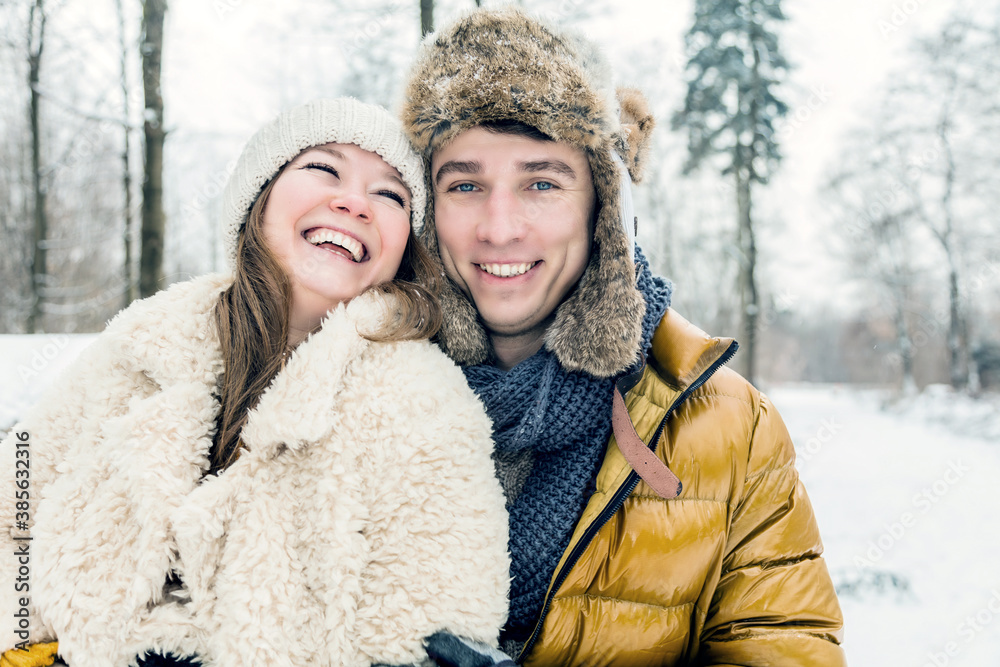 happy loving couple walking in snowy winter forest, spending christmas vacation together. Outdoor seasonal activities happy loving couple walking in snowy winter forest, spending christmas vacation together. Outdoor seasonal activities