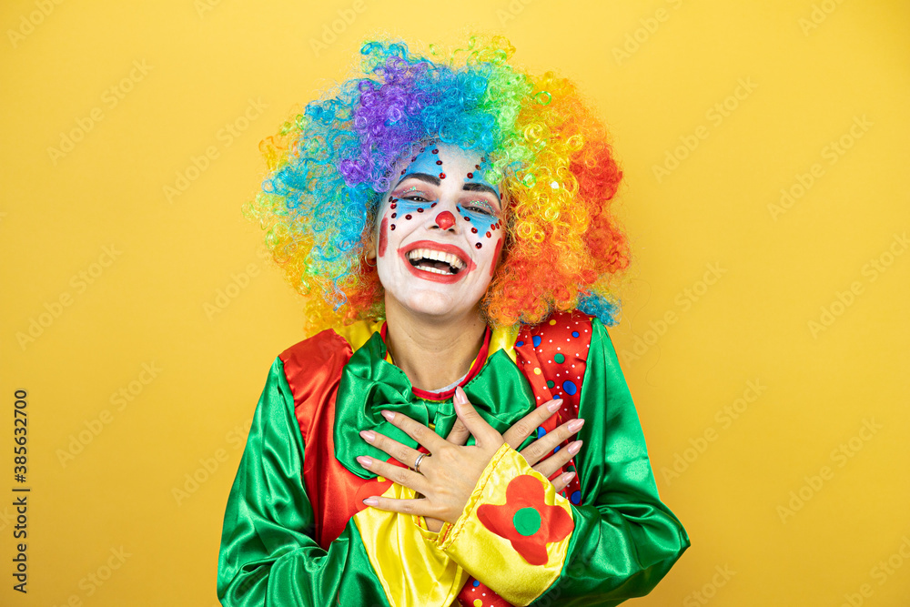 Clown standing over yellow insolated yellow background smiling with her hands on her chest and grateful gesture on her face. Clown standing over yellow insolated yellow background smiling with her hands on her chest and grateful gesture on her face.