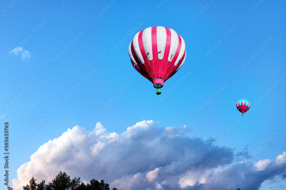Fototapeta premium Red hot air balloons on background of blue cloudy sky.