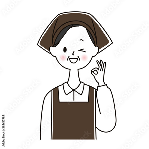 OKサインを出すエプロン姿のシニア女性