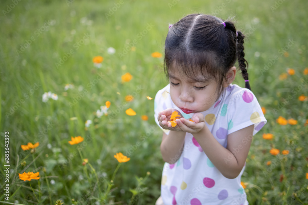 Little asian girl blowing off yellow flower petals in the field. Little asian girl blowing off yellow flower petals in the field.