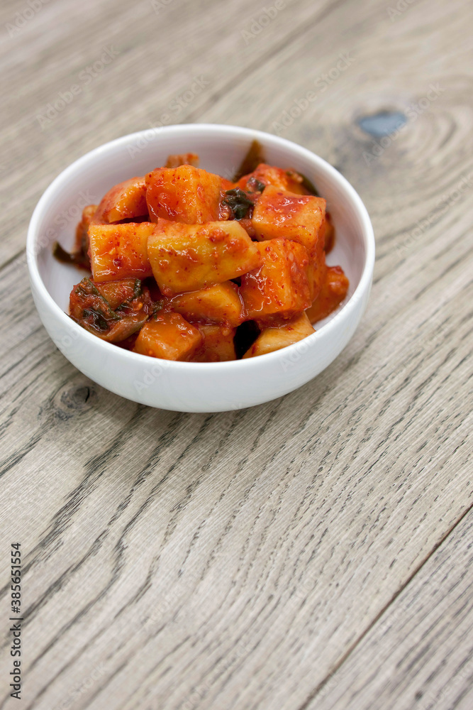 Korean traditional radish kimchi (kkakdugi) on wooden table Korean traditional radish kimchi (kkakdugi) on wooden table