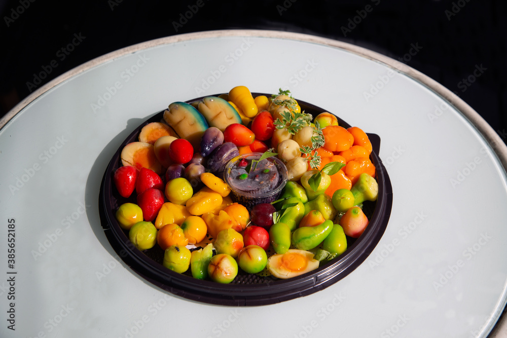 Fruit shaped like a clear glass The inside is made of nuts in jelly that imitates fruit. Is a traditional Thai dessert.on a table. Fruit shaped like a clear glass The inside is made of nuts in jelly that imitates fruit. Is a traditional Thai dessert.on a table.