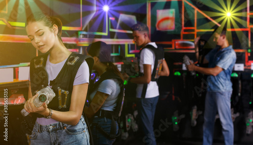 Group portrait of people looking laser guns and clothes together before game