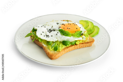 Sandwich with fried egg and avocado on plate against white background
