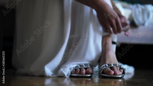 Bride putting on wedding shoes photo
