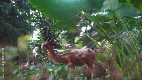 Deer statue surrounded by trees photo