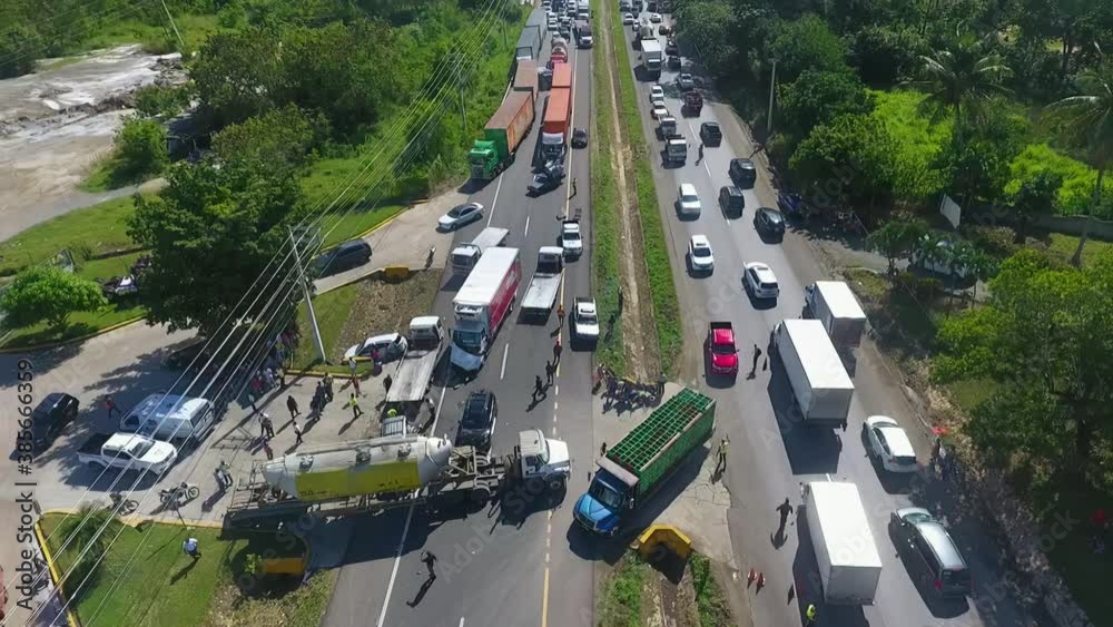Aerial view of a truck and car collision, causing a jam queue of traffic on a highway, in South Africa - tilt up, pan, drone shot