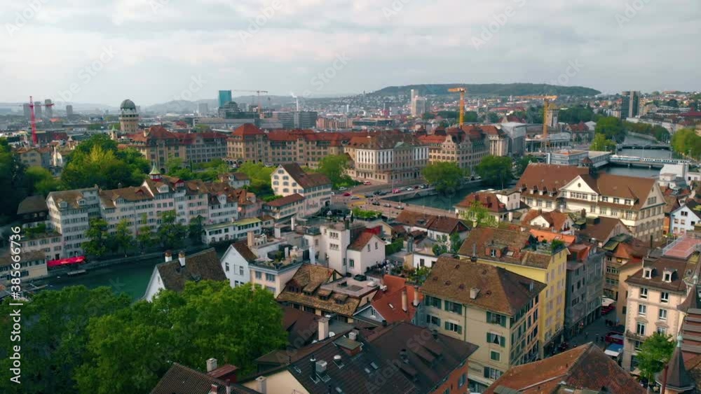 Aerial view low over rooftops in the city, towards a bridge, Limmat river and the Zurich train station Hauptbahnhof, sunny day, in in Switzerland - dolly, drone shot Aerial view low over rooftops in the city, towards a bridge, Limmat river and the Zurich train station Hauptbahnhof, sunny day, in in Switzerland - dolly, drone shot