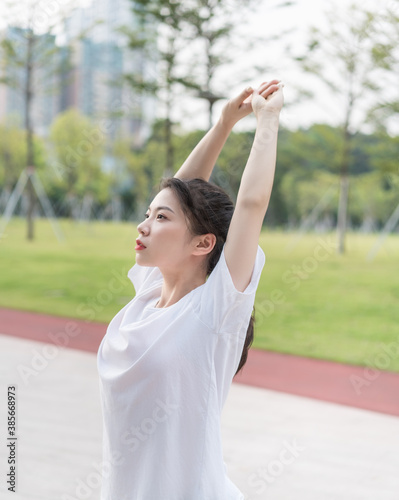 Young long-haired woman is doing exercises in the park  © Anciens