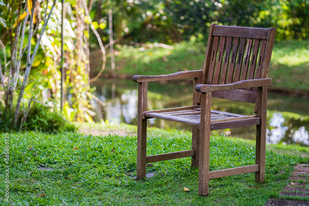 Old wooden chair in a tropical garden near the lake in island Borneo, Malaysia