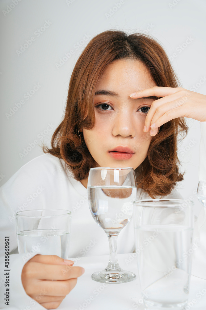 Asian woman with water glasses on table isolate on white background. Asian woman with water glasses on table isolate on white background.