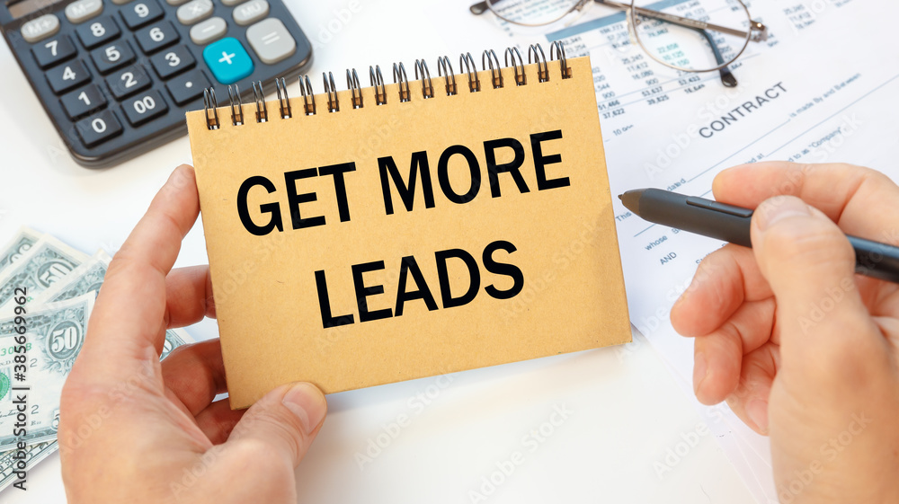 Office desk with devices and documents. Get more leads - inscription on notepad . Office desk with devices and documents. Get more leads - inscription on notepad .