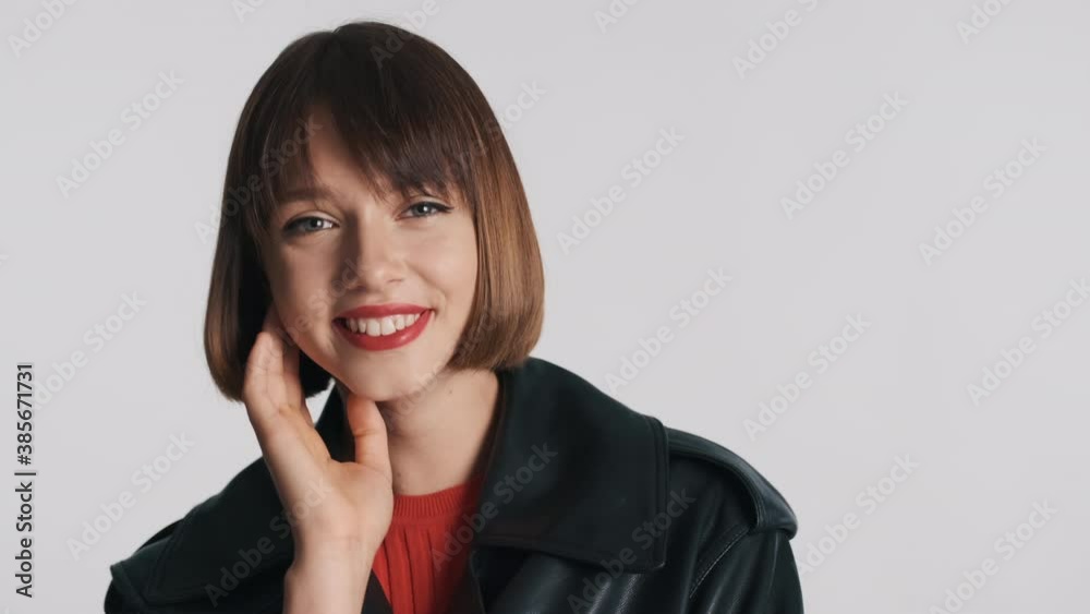 Beautiful cute brunette girl happily smiling on camera over white background. Face expression Beautiful cute brunette girl happily smiling on camera over white background. Face expression