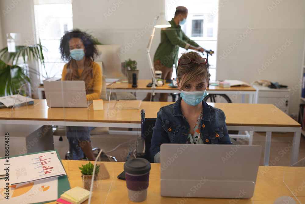 Office colleagues wearing face masks working in office Office colleagues wearing face masks working in office