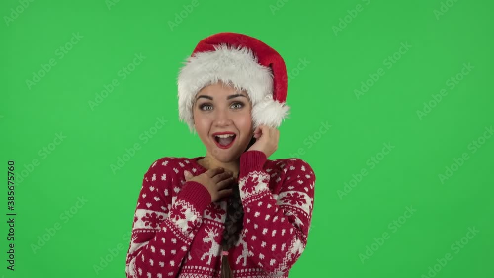 Portrait of sweety girl in Santa Claus hat is saying wow with coquettishly smile. Green screen Portrait of sweety girl in Santa Claus hat is saying wow with coquettishly smile. Green screen
