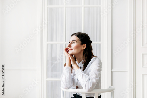 Girl in light clothes sitting on a chair in a room, light interior, model, portrait, beauty, youth, self-care, consultant, work, Manager