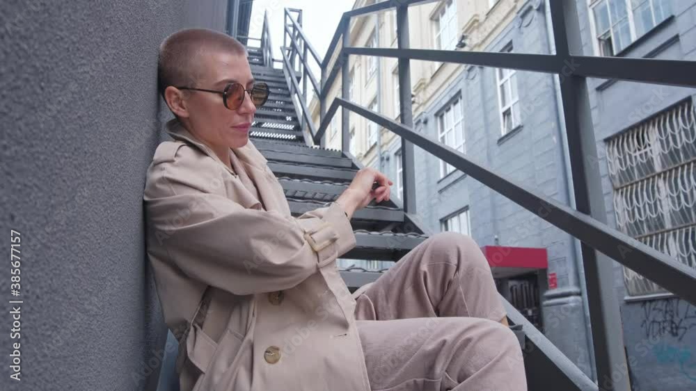 A woman with short hair smoking electronic cigarettes outdoors. A woman with short hair smoking electronic cigarettes outdoors.