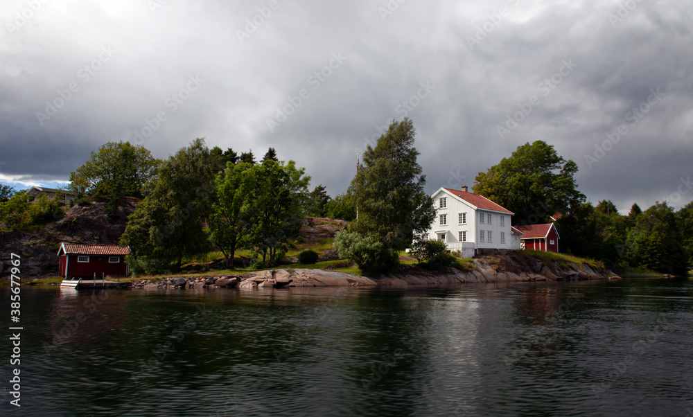 Fototapeta premium Old style wooden white house by the sea in southern Norway