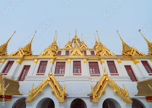 Loha Prasat Wat Ratchanatda pagoda, a buddhist temple or Wat Saket buildings with blue sky in Bangkok Downtown, urban city, Thailand. Thai Landmark. Architecture. photo