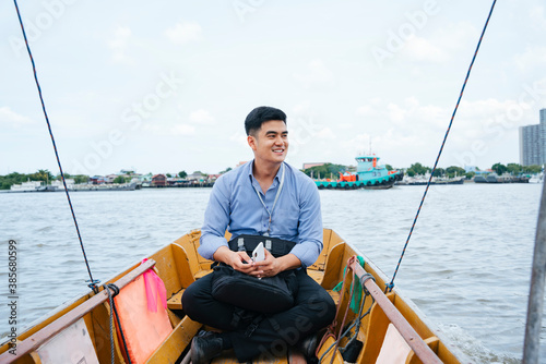 Business man travel by a boat in Bangkok.