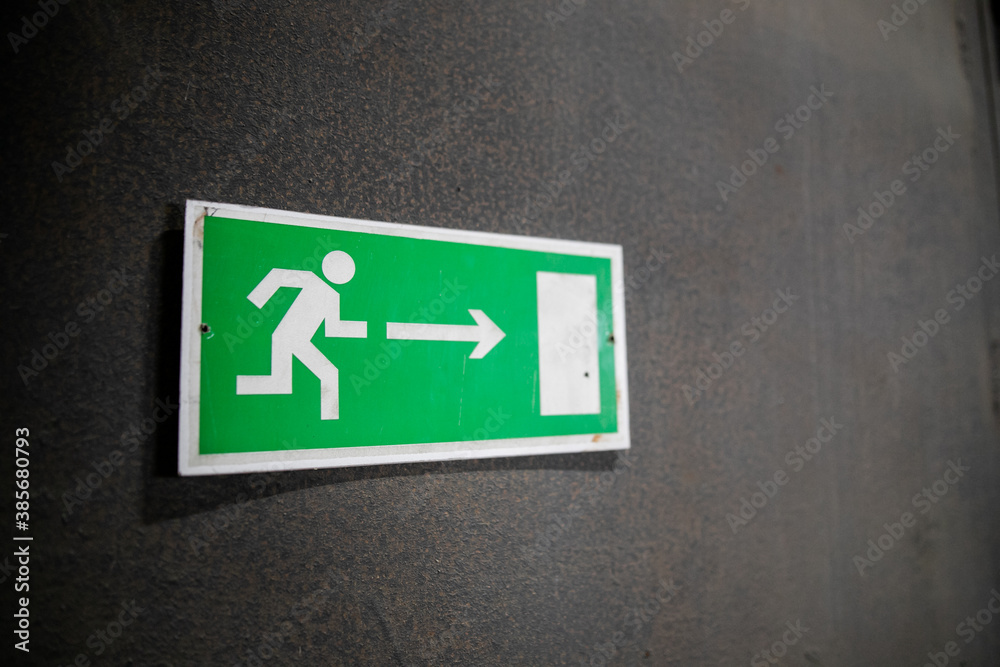 Emergency exit sign, escape sign on the wall. Safety sign in office