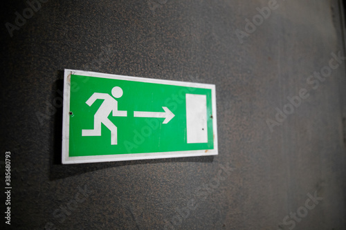 Emergency exit sign, escape sign on the wall. Safety sign in office company for exit building.