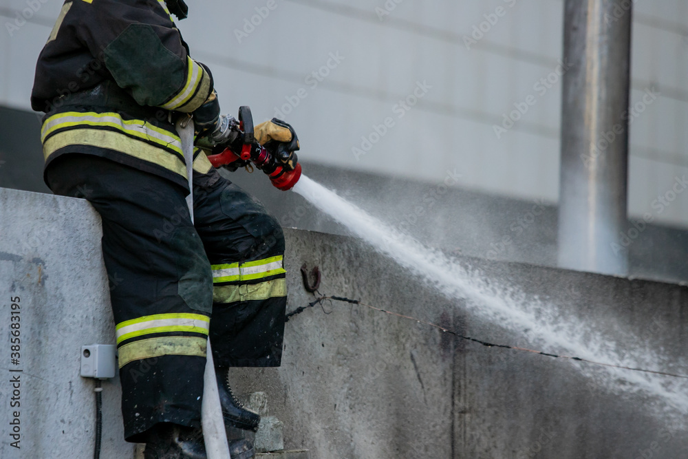 Firemen using extinguisher and water from hose for fire fighting in firefight training. Firefighter wearing fire suit for protect and safety under danger case.This team is under civil service system. Firemen using extinguisher and water from hose for fire fighting in firefight training. Firefighter wearing fire suit for protect and safety under danger case.This team is under civil service system.