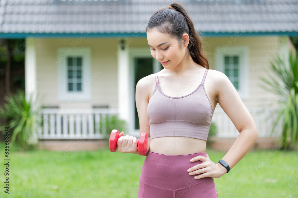 Female fitness instructor exercising with small dumbbell on frontyard. Female fitness instructor exercising with small dumbbell on frontyard.