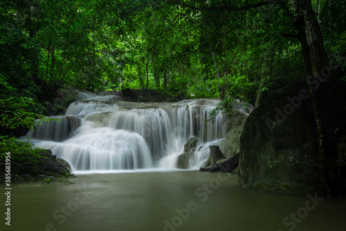 A beautiful waterfall deep in the tropical forest, steep mountain adventure in the rainforest. © tomruethai