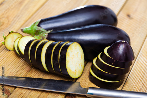 Sliced eggplant or aubergine on wooden table, food preparation
