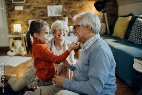 Cute small girl spending time with her grandparents at home. photo