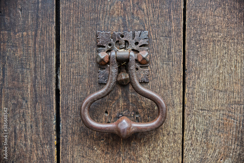 Close up of an old door handle knocker on an old wooden brown door.Paris, france