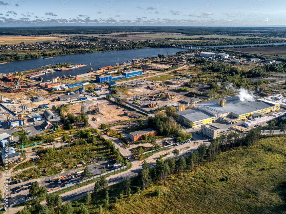 industrial plant on the bank of a large river, aerial view.