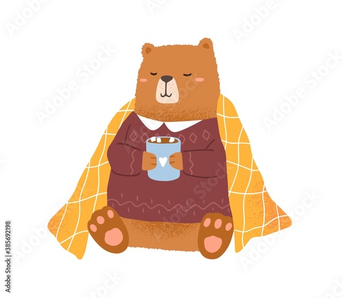 Childish bear holding cup with hot cocoa with marshmallow vector flat illustration. Funny animal in warm sweater isolated on white. Amusing teddy covered with comfy blanket relaxing at winter season