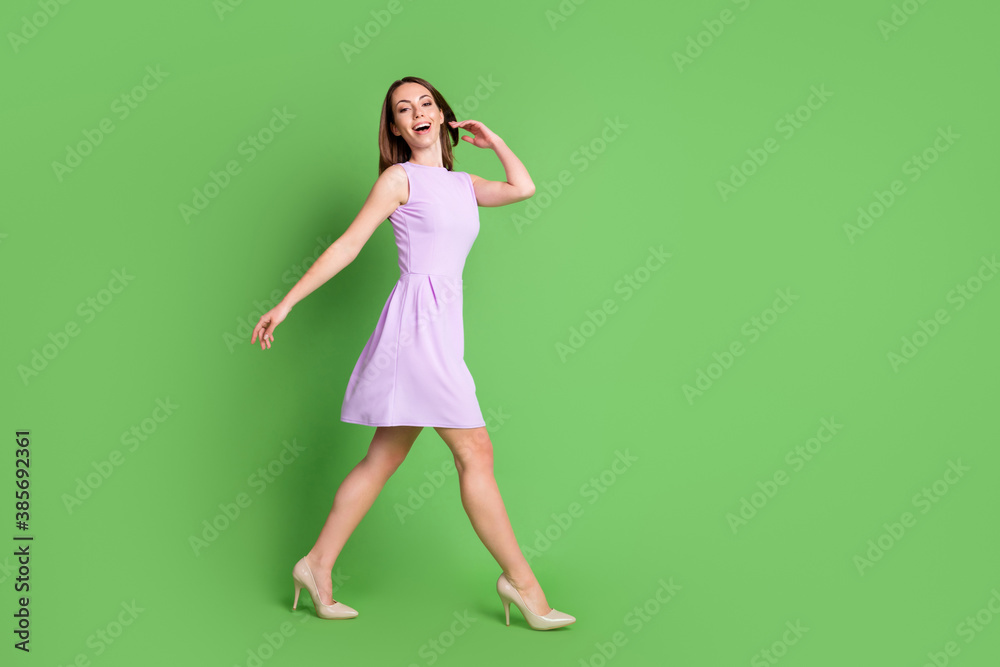 Full body profile photo stylish gorgeous girl lady open mouth go forward hand touch hair joyful walking beauty salon advert concept wear purple dress isolated pastel green color background Full body profile photo stylish gorgeous girl lady open mouth go forward hand touch hair joyful walking beauty salon advert concept wear purple dress isolated pastel green color background