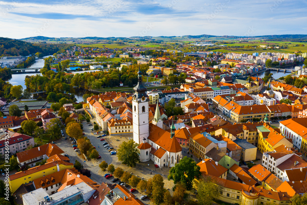 Scenic view from drone of historic center of small Czech town of Pisek on banks of Otava river with Church of Nativity of Blessed Virgin Mary on autumn day..