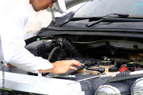 Man checking the car engine and master repairs under the hood of the car, and car insurance concept 