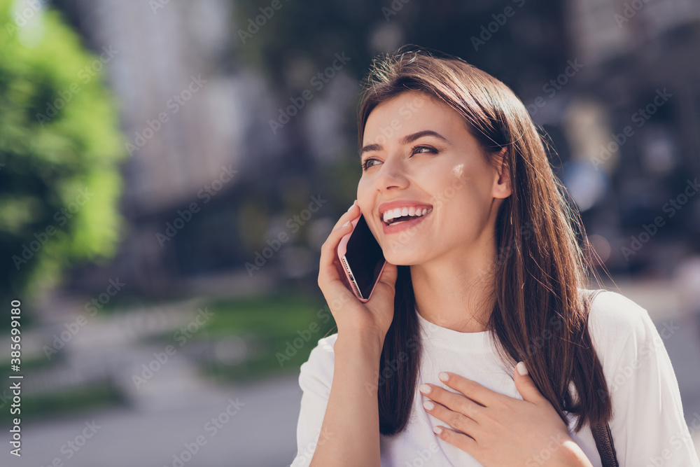 Photo portrait of laughing girl touching chest with hand talking on phone in park Photo portrait of laughing girl touching chest with hand talking on phone in park