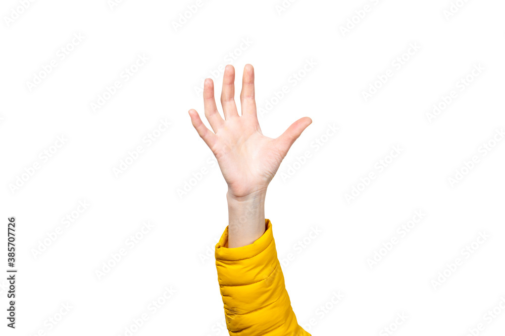Female hand in a yellow jacket reaches for something on a light background Female hand in a yellow jacket reaches for something on a light background