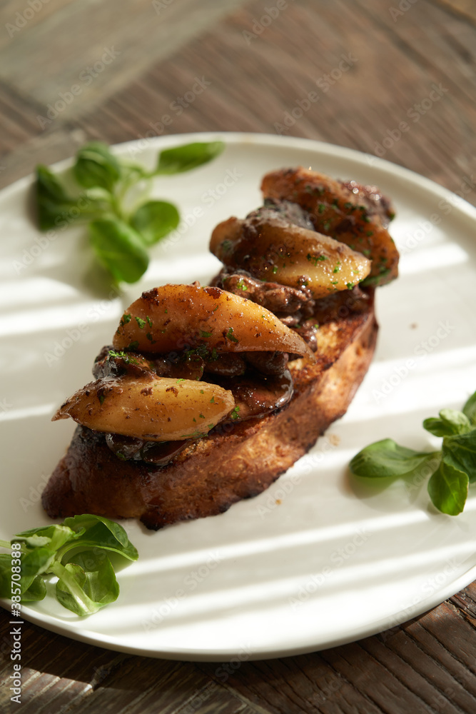 Toast with baked chicken liver on white plate on table Toast with baked chicken liver on white plate on table