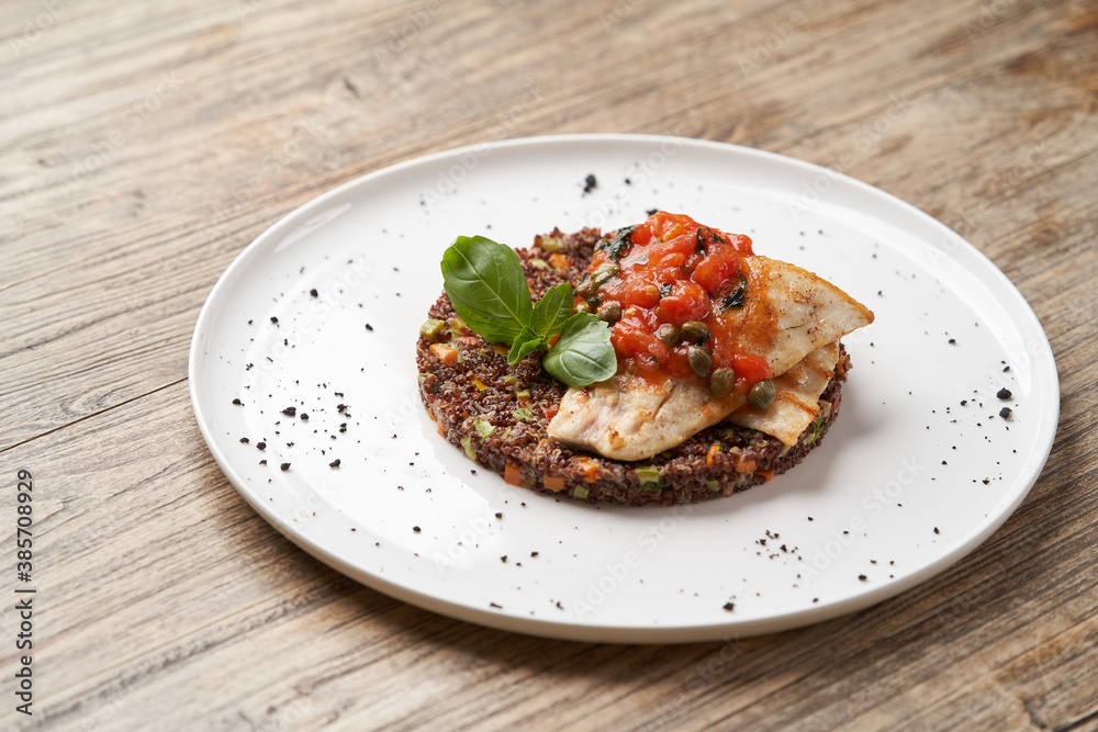 Sea bass fish with quinoa risotto. Sea bass with red quinoa, herb and vegetable salad
